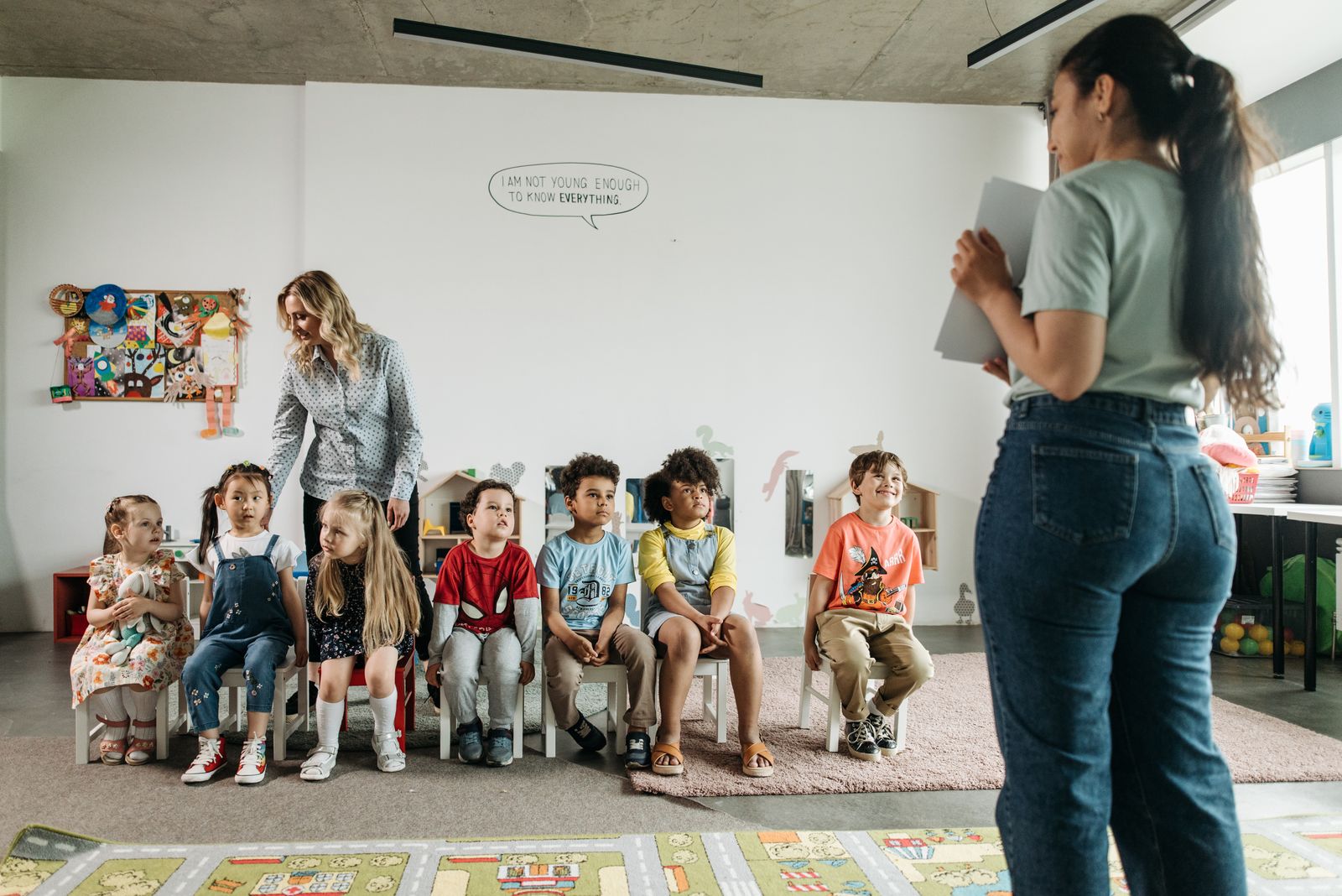 Professoras acolhendo turma de crianças em sala de aula